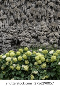 Lower Section Of Grotesque Stalactite Wall Above Flowerbed With Hydrangeas, Prague, Czech Republic.