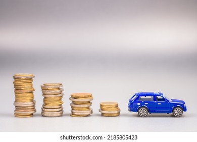 Lower Stack Money With A Small Blue Car At The End, Save The Money For Buying A New Car, Car And Budget, Finance And Insurance, Use Money Less About The Car