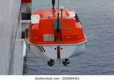 Lowering Orange Totally Enclosed Lifeboat To Water. Abandon Ship Drill. Lifeboat Training. Man Over Board Drill.