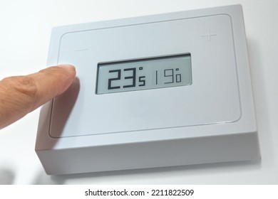 Lowering The Temperature Of A Home Thermostat Due To Energy Crisis. Close Up.