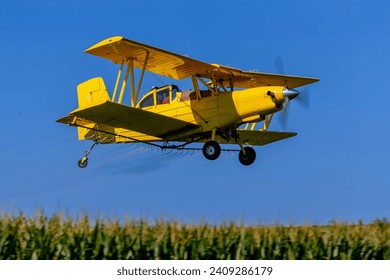 Low-flying crop duster combats pests, safeguarding fields with precision chemical spraying for insect control, ensuring healthy crop yields. - Powered by Shutterstock