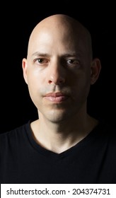 Low-key Dramatically Lighted Portrait Of A 40 Year Old Man On Black Background 