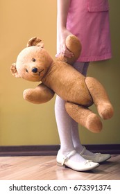 Lowsection Side View Of A Girl Holding Teddy Bear In Home