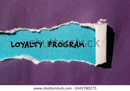 Loyalty program words written on purple torn paper with blue background. Conceptual symbol. Copy space.