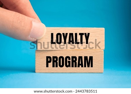 Loyalty program words written on wooden blocks with blue background. Conceptual symbol. Copy space.