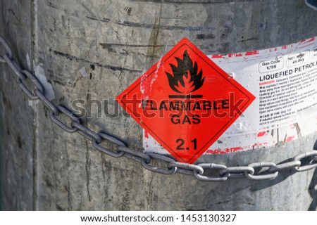 An LPG tank secured with a strong chain and showing a Flammable Gas 2.1 sign