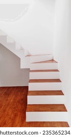 The L-style staircase is one of the most popular staircase layouts because you can build it in narrow or wide spaces. - Shutterstock ID 2353652345