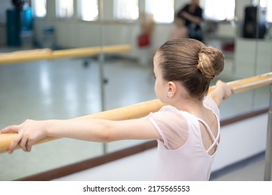 Lttle Girl Toddler Ballerina In Pale Pink Tutu And Ballet Shoes Practicing Dance Moves.