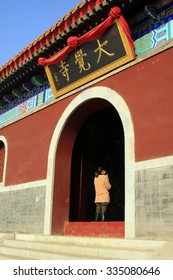 LUAN COUNTY - January 10: A Woman Walking Through The Big Doorway In Dajue Temple, January 10, 2015, Luan County, Hebei Province, China
