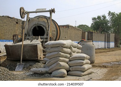 LUANNAN COUNTY - AUGUST 15: bags of cement and concrete mixer in the construction site, on august 15, 2014, Luannan County, Hebei Province, China  
