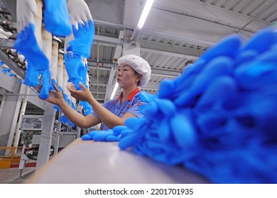 LUANNAN COUNTY, China - May 6, 2022: Female Workers Work Hard On The Nitrile Glove Production Line In North China