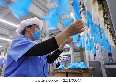 LUANNAN COUNTY, China - May 6, 2022: Female Workers Work Hard On The Nitrile Glove Production Line In North China