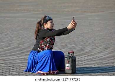 LUANNAN COUNTY, China - November 14, 2021: a woman takes photos with her mobile phone in the park, North China