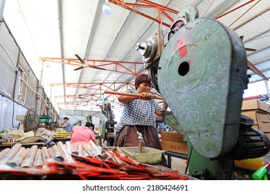 LUANNAN COUNTY, China - September 14, 2021: Workers Work Hard On The Sickle Processing Production Line, North China

