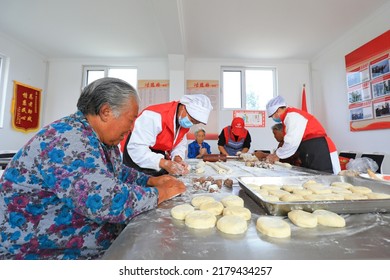 LUANNAN COUNTY, China - September 16, 2021: Volunteers And Old People Make Traditional Chinese Moon Cakes In A Village