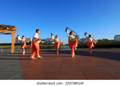 LUANNAN COUNTY, China - September 21, 2021: People Are Practicing Tai Chi Sword On The Wooden Platform Of The Park, North China