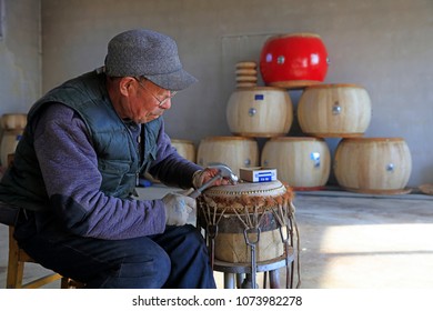 Luannan County - February 6, 2018: craftsman is working on the drum in workshops, Luannan, Hebei, China