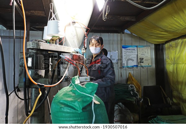 LUANNAN COUNTY, Hebei\
Province, China - March 17, 2020: Workers are busy in the feed\
packaging production\
line.