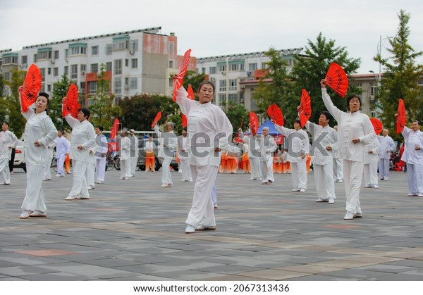 Luannan County, Hebei Province, China --\
October 10, 2021. A group of women perform Chinese Tai Chi kung fu\
fan in an organized performance in the\
square