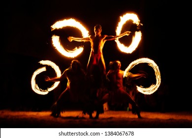 Luau Hawaii, French Polynesia fire dance silhouettes of professional dancers at night on beach resort tiki party.