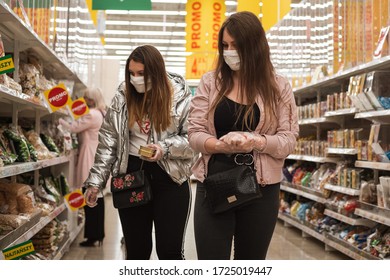 LUBIN, POLAND - MAY 7, 2020. Two Young Women With Face Masks And Plastic Gloves During Shopping In Auchan Supermarket.
