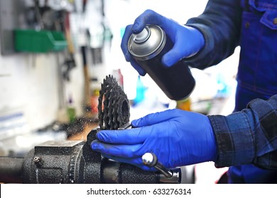 Lubrication And Maintenance Of The Bicycle. The Mechanic In The Bike Service Lubricates The Bicycle With Grease.