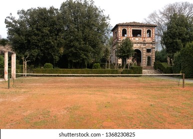 Lucca, Italy - 3/4/2019 - Tennis Net On An Old Lawn Tennis Court At The Villa Torrigiani Estate, In Front Of An Outbuilding Used As An Old Locker Room