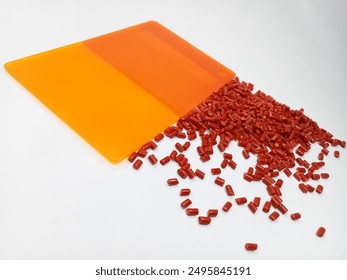 Lucent orange polymer masterbatch granules isolated on white background for industrial plastic product catalog banner design