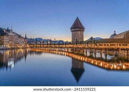 Lucerne, Switzerland with the Chapel Bridge and water tower over the River Reuss at dawn.