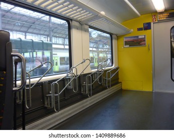 Lucerne - Switzerland / May 25, 2019. An Empty Bike Rack In A Swiss Train, Waiting In The Railway Station Of Lucerne. On The Window Is Visible The Bicycle Logo.