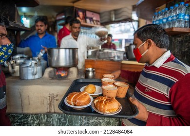 Lucknow, Uttar Pradesh, India, Feb 18 2022: waiter serving kulhad tea with Bun Makkhan and Samosa at Sharma tea stall in hazratganj old lucknow.
