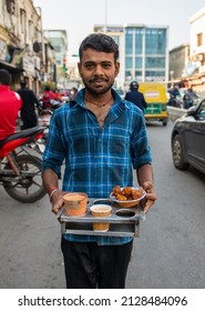 Lucknow, Uttar Pradesh, India, Feb 18 2022: waiter serving kulhad tea with snacks in hazratganj old lucknow.