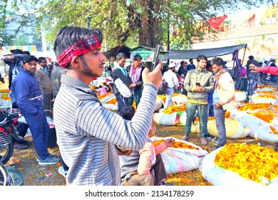 Lucknow,UP,03 02 2022: Young Flower Grower Takes Time Off In Flower Market To Make A Mobile Video.