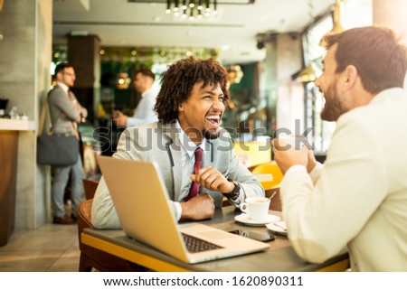It's lucky to do the job you love. Two businessman siting in the cafe and they talk business