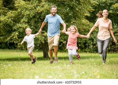 Lucky Family With Two Kids Togehter In Spring At The Park