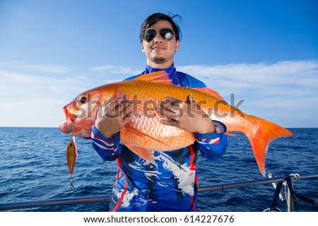 Lucky fisherman holding a beautiful goldfish