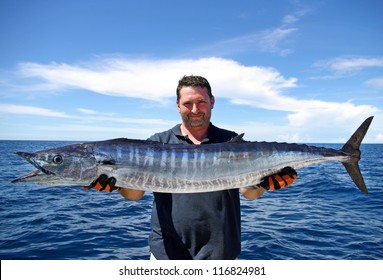 Lucky  fisherman holding a beautiful wahoo fish