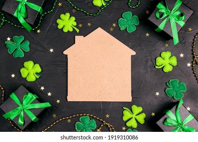 Lucky home symbol surrounded by gifts, four-leaf clover and stars on black background. Copy space for text. St.Patrick's day concept.  - Powered by Shutterstock