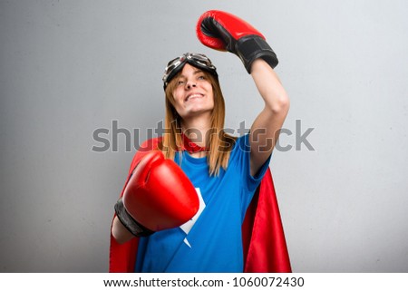 Lucky superhero girl with boxing gloves on a gray textured background