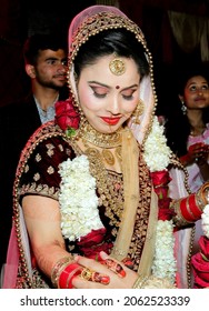 Ludhiana 7th March 2019 - Portrait of Hindu girl, beautiful stunning Indian hindu bride wearing a red traditional wedding dress, embroidered lehenga with heavy gold jewelery and a veil Smile tender