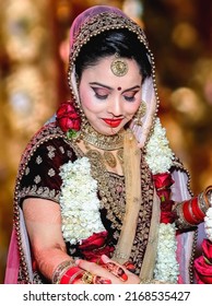 Ludhiana 7th March 2019 - Portrait of Hindu girl, beautiful stunning Indian hindu bride wearing a red traditional wedding dress, embroidered lehenga with heavy gold jewelery and a veil Smile tender  