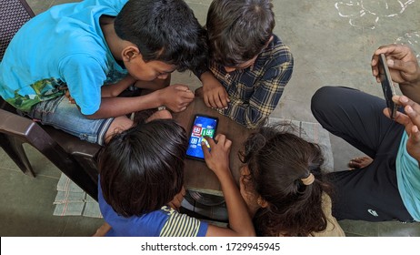 Ludo Game. Children Are Sitting At Home Playing Ludo Game On Mobile. Lockdown In India. Man Using Smartphone For Play Game And Watching Videos.