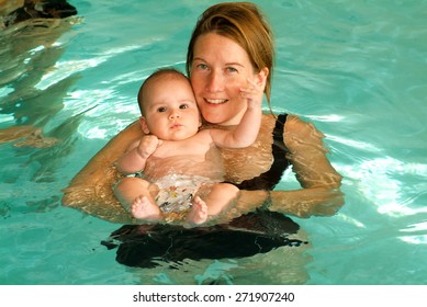 Lugano, Switzerland - 18 October 2007: Adorable baby enjoying swimming in a pool with his mother, early development class for infants teaching children to swim and dive