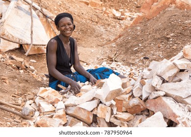 Lugazi, Uganda. June 18 2017. A Ugandan woman breaking rocks into small slabs for her foreman. 