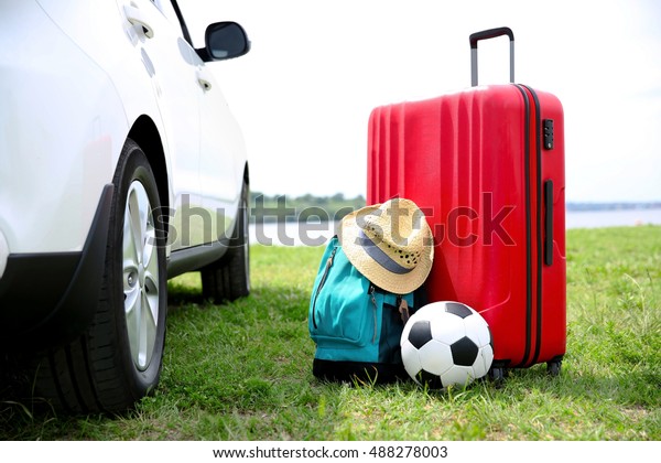 Luggage and\
accessories near car. Travel\
concept