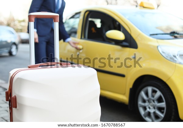 Luggage of\
businessman catching taxi\
outdoors