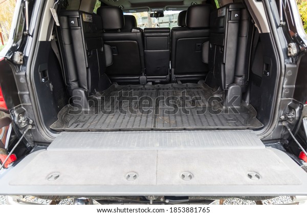 Luggage space in the body of the SUV car trunk\
with rubber mat and open rear door and leather interior after\
washing and dry cleaning with three rows of seats. Auto service\
industry. Travel\
concept.