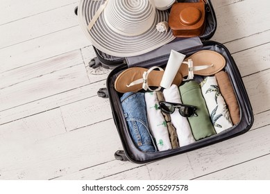Luggage and suitcase packing for vacation on white wooden background in studio 
