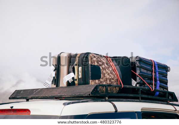 Luggages and Bags arranged on the car roof\
ready for a trip in sky\
background