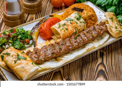 lula kebab spicy with vegetables in Turkish on the board